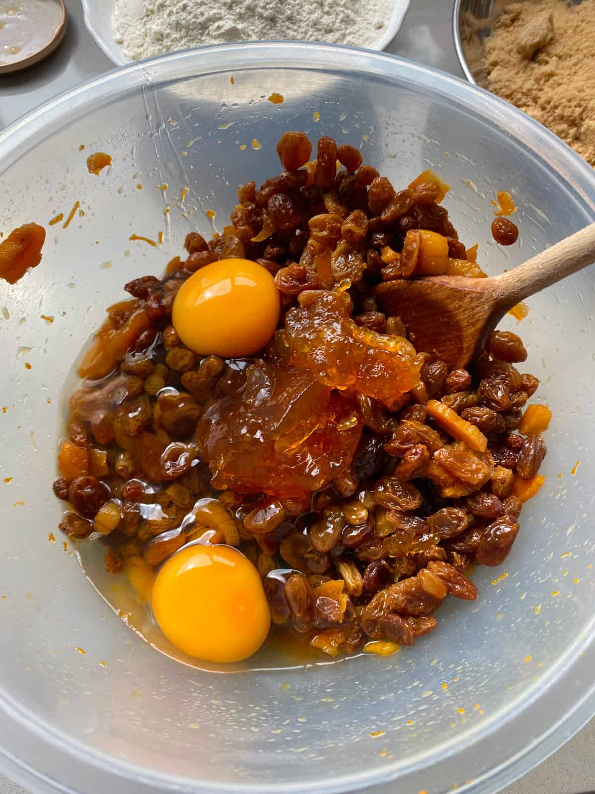 Soaking friend fruit, cracked eggs and a dollop of marmalade in a large mixing bowl.