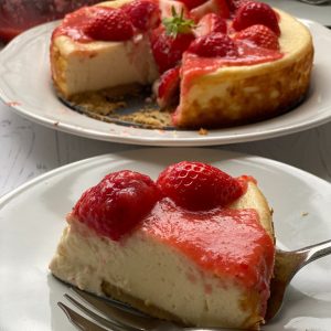 Slice of strawberry cheesecake on a white plate