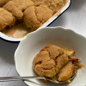 Portion of Rhubarb and Apple Cobbler in a white dish.