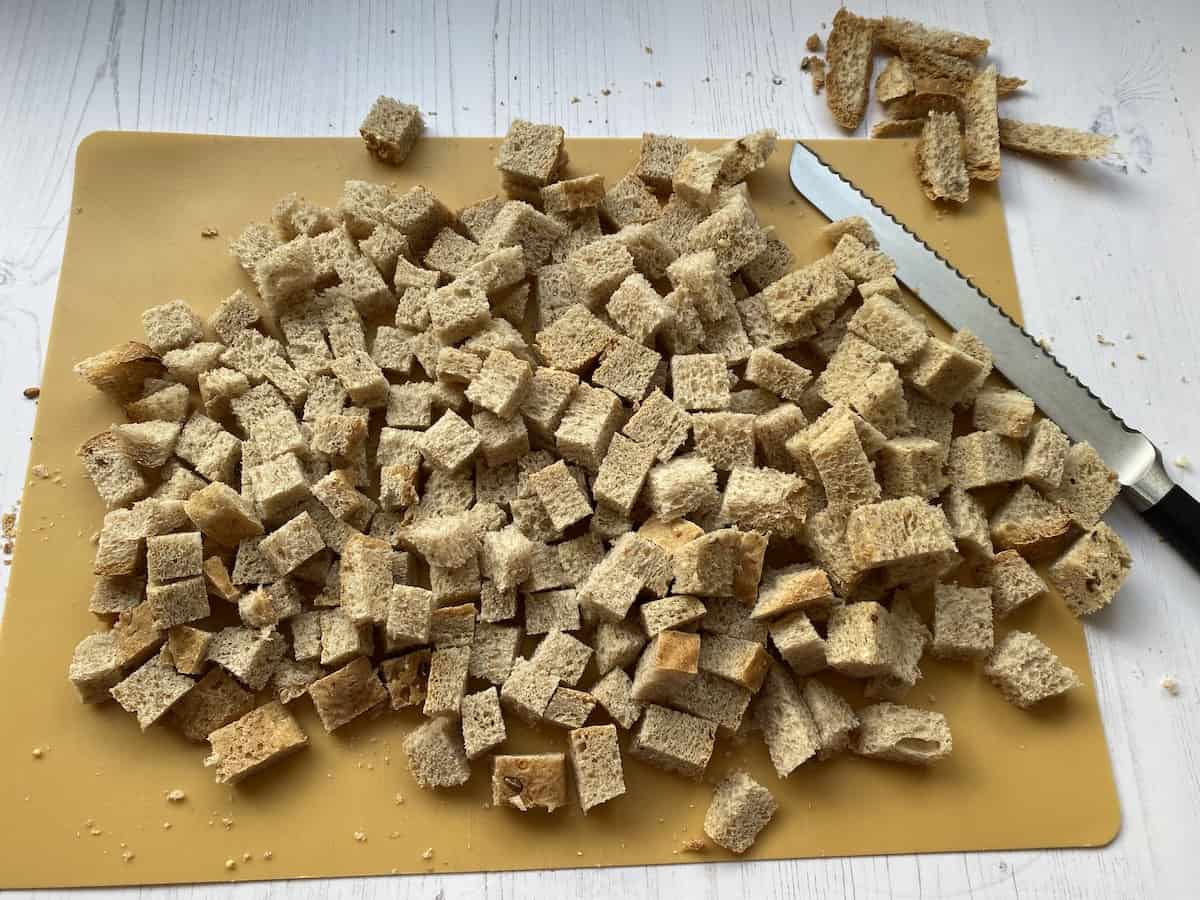 Cubes of bread on a chopping board.