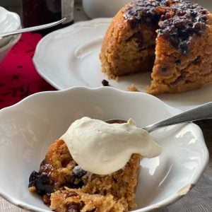 Slice of Mincemeat Sponge pudding with cream on the top.