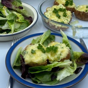 Twice Baked Potatoes (Jacket Potatoes) served with a salad in a dish.