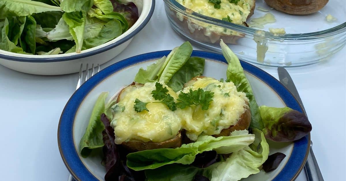 Twice baked potatoes served with a salad in a dish.