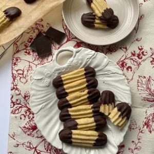 Chocolate Dipped Viennese Fingers on a white plate.