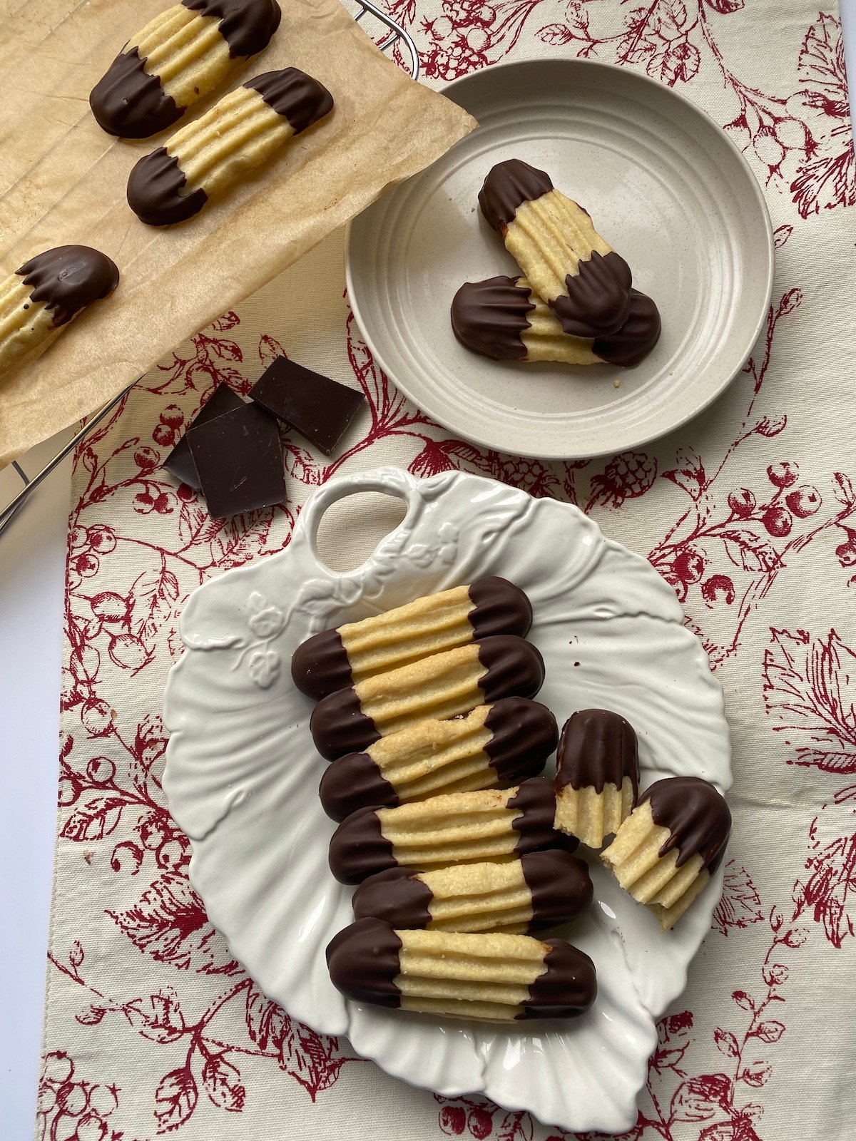 Chocolate Dipped Viennese Fingers on a shite plate.