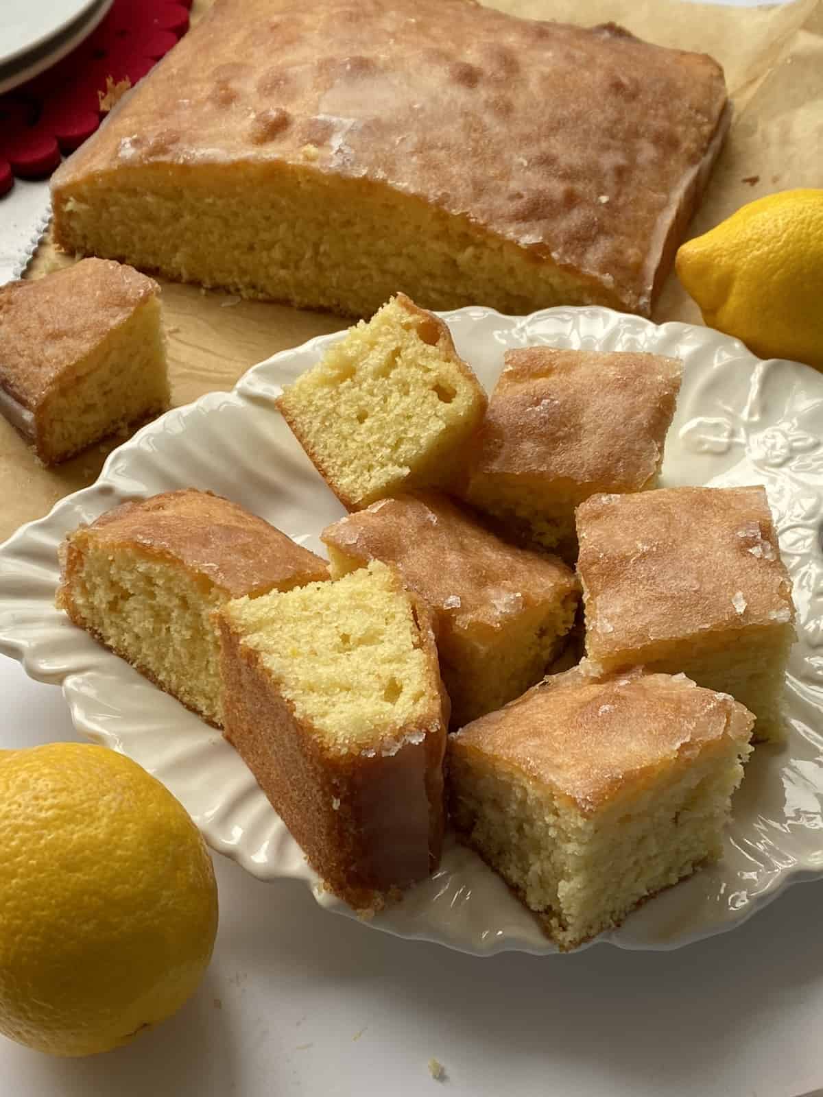 Slices of Lemon Drizzle Traybake on a white plate.