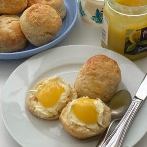 Plate of eggless scones with cream and lemon curd.