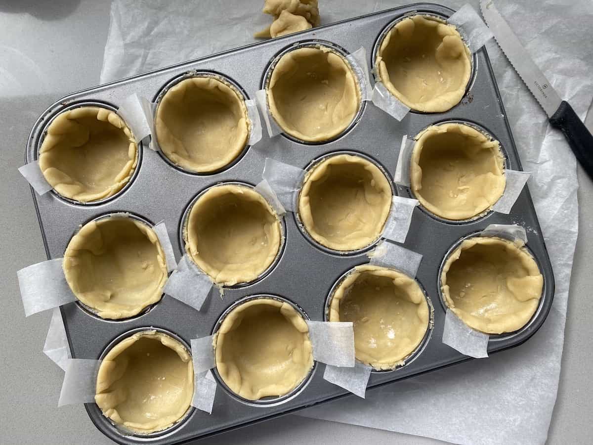 Small Pastry shells in a muffin tin.