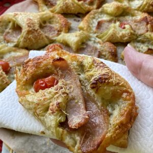 Cheese and Bacon turnovers with one in a hand.